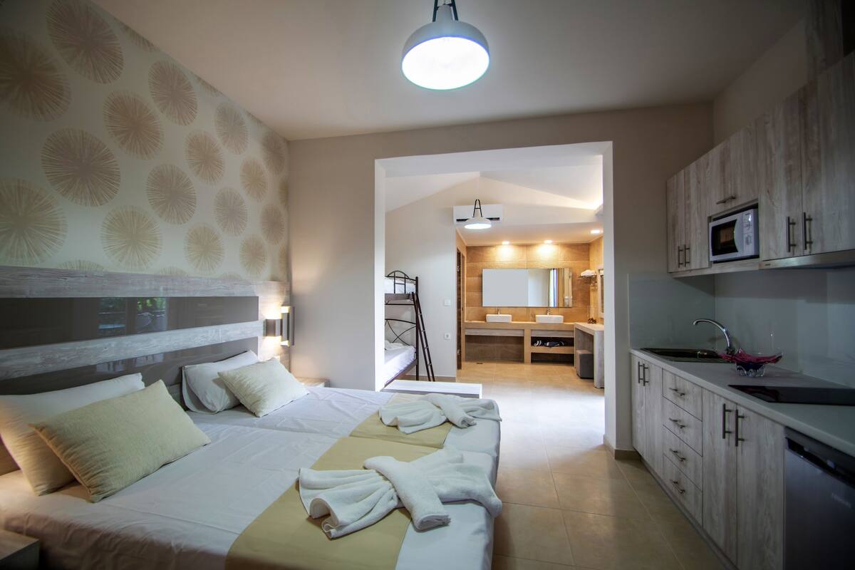 Habitación de hotel con cama, baño y kitchenette.