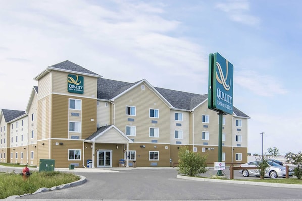 A multi-story hotel with a sign indicating it is a Quality Inn & Suites.