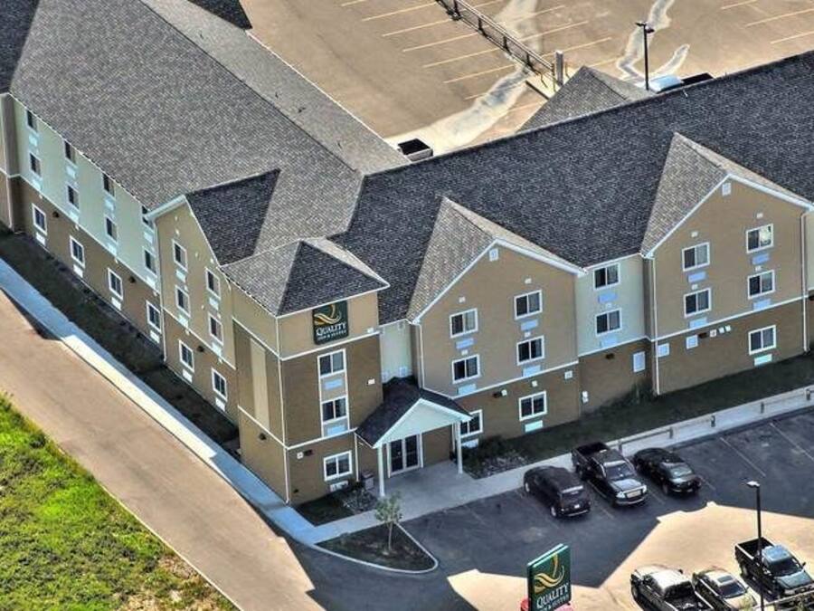 Un hôtel à plusieurs étages, doté d’un parking et d’un petit espace vert.