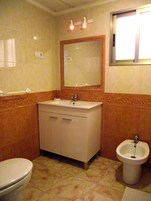 Un baño con inodoro, lavamanos y bidé.