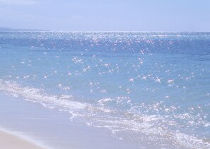Una playa con cielo despejado y mar tranquilo.