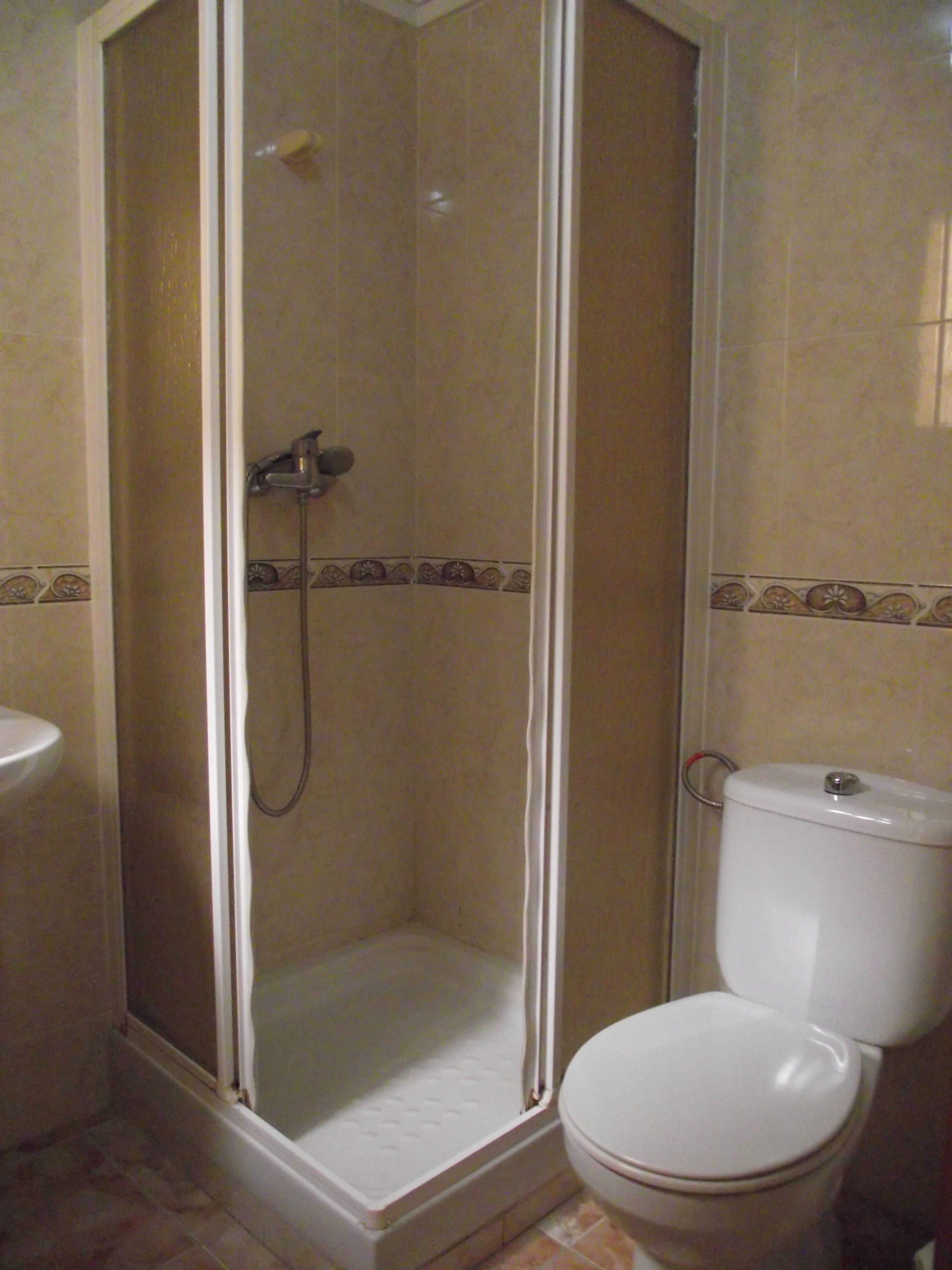 Une salle de bain équipée d’une douche, de toilettes et d’un lavabo.