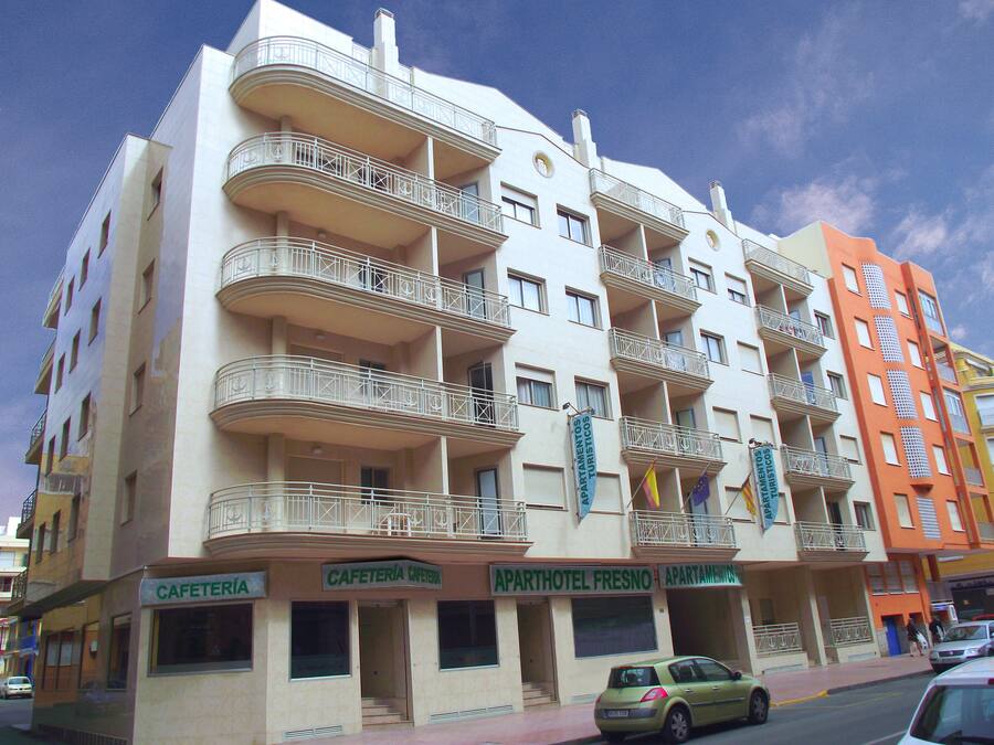 Un hotel de varios pisos con balcones, un café y un restaurante.