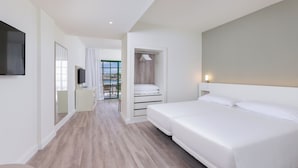 A modern hotel room with a large bed, a TV mounted on the wall, and a walk-in closet with a mirror.