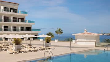 Utomhuspool, parasoller och solstolar