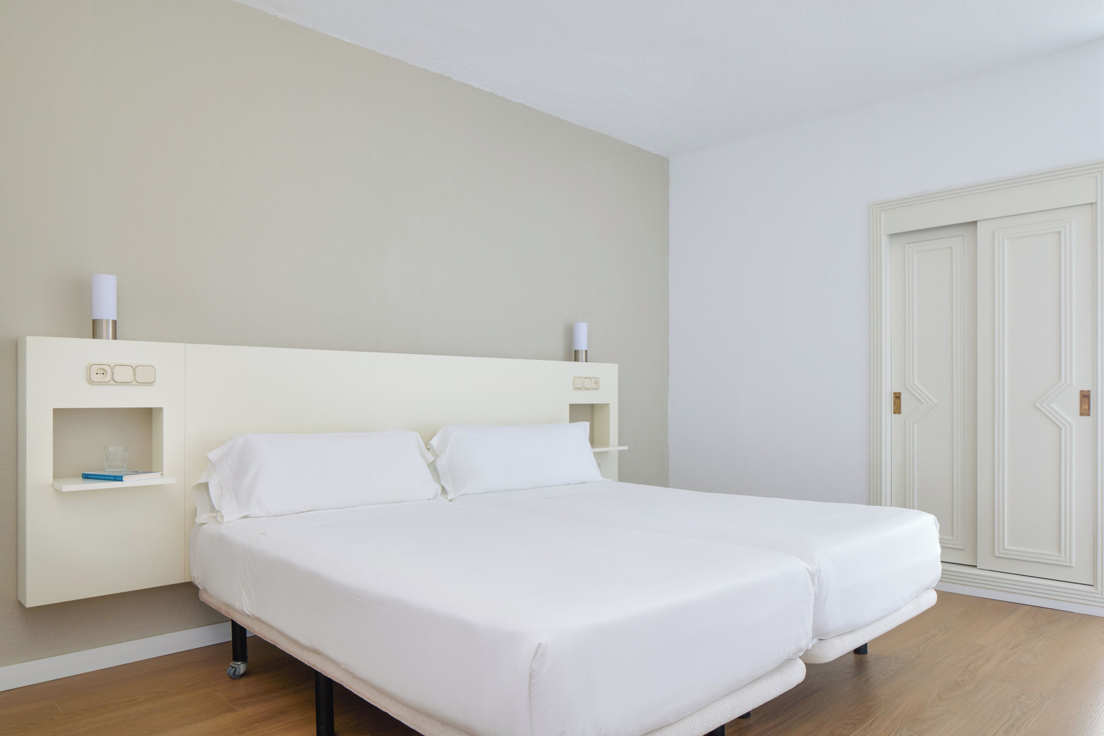 Un dormitorio con cama, mesitas de noche y armario.