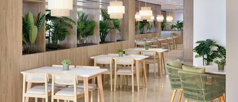 A modern interior with wooden walls, white tables, and green chairs.