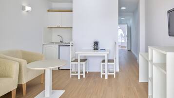 Un espacio habitable moderno y minimalista con cocina, comedor y zona de estar.