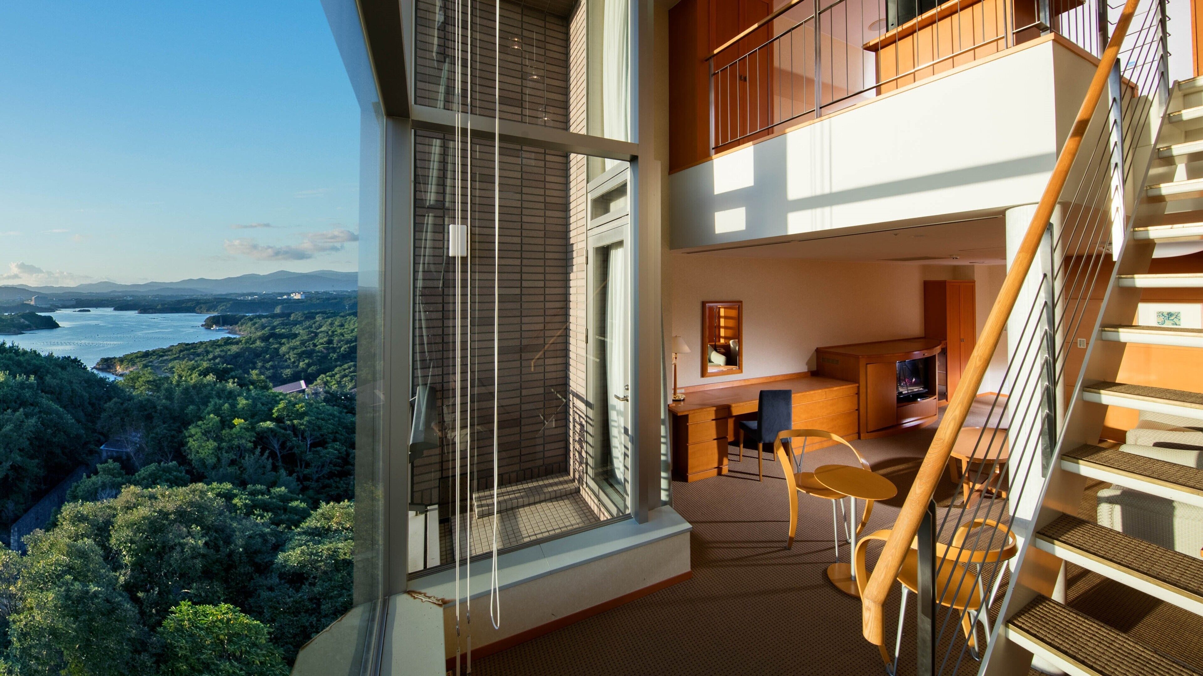 Un appartement moderne doté d’un balcon, d’un coin repas et d’un escalier.