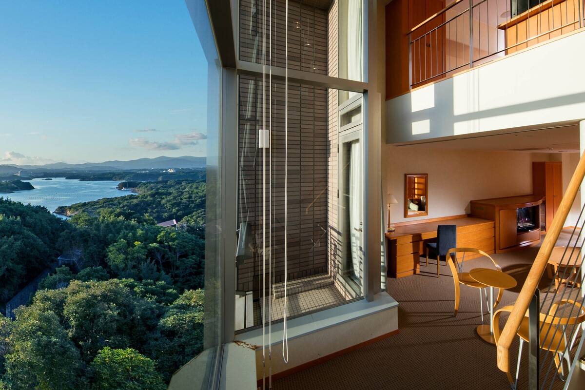 Un appartement moderne doté d’un balcon, d’un coin repas et d’un escalier.