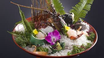 Un cuenco de mariscos con diferentes guarniciones y una planta decorativa.