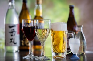 Variedad de vasos y botellas sobre una mesa, presumiblemente con diferentes bebidas.