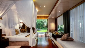 A bedroom with a canopy bed, a sofa bed, a TV, and a view of the garden.