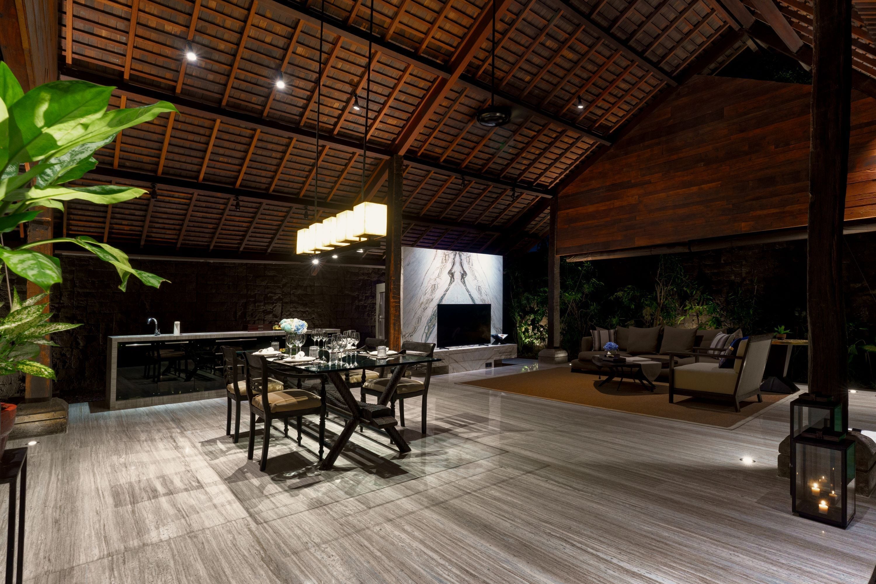 A spacious indoor area with a dining table, chairs, a bar, and seating.