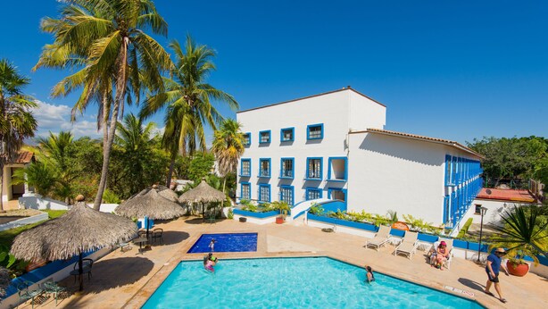 A resort with a swimming pool, palm trees, and a white building with blue accents. - Azul Sirena (Santa María Huatulco)