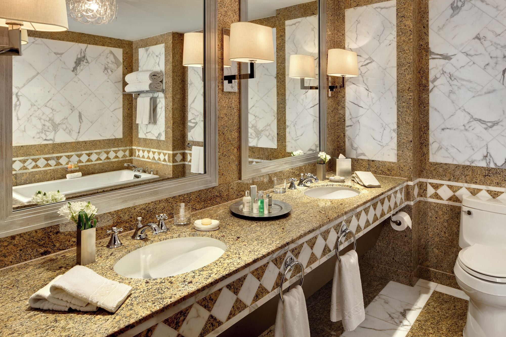 A bathroom with two sinks, a toilet, and large mirrors.