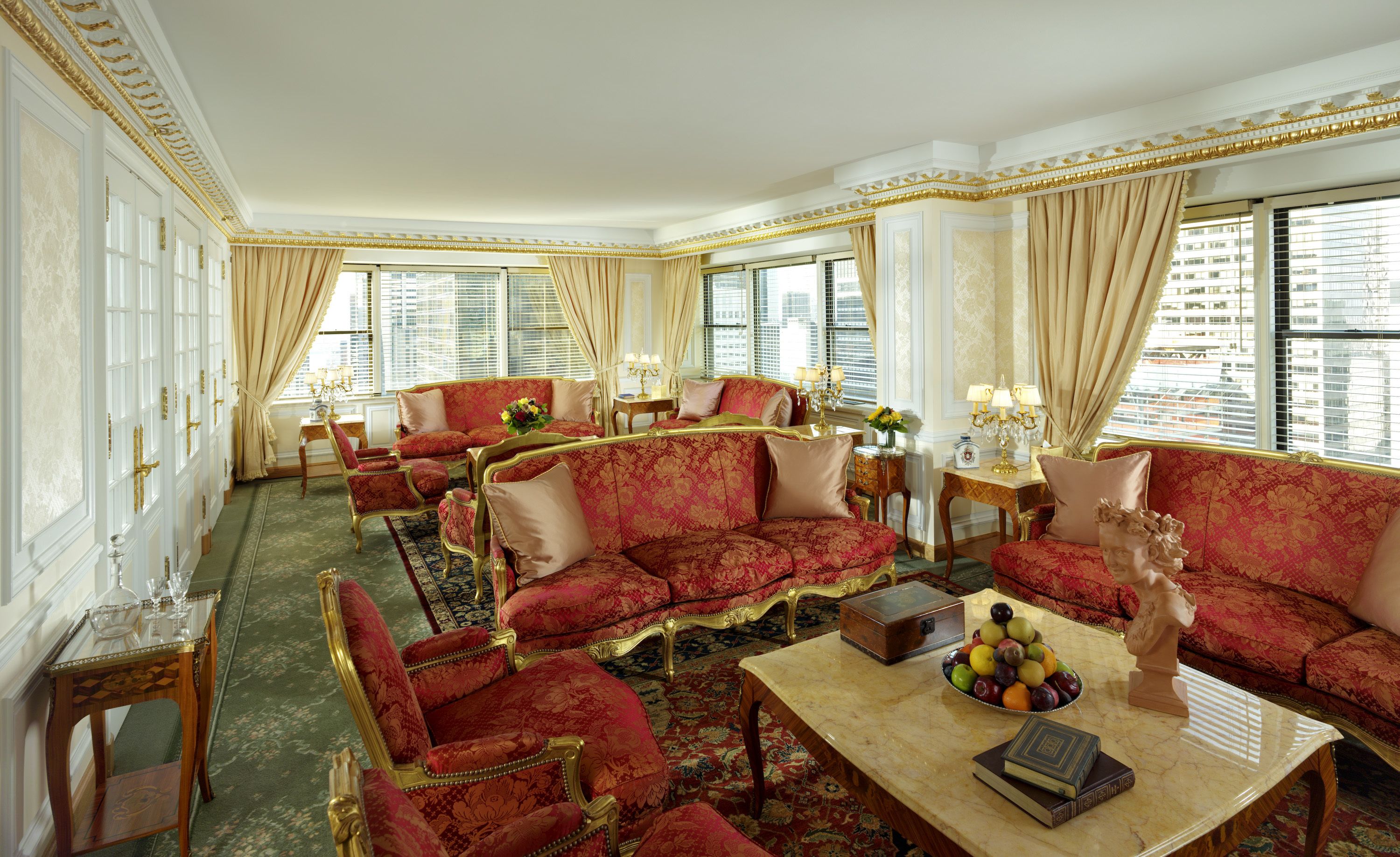 A luxurious room with ornate furniture, large windows, and a view of the city.