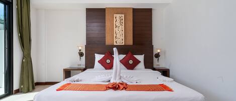 A hotel room with a large bed, two nightstands, a wooden headboard, and a window with curtains.