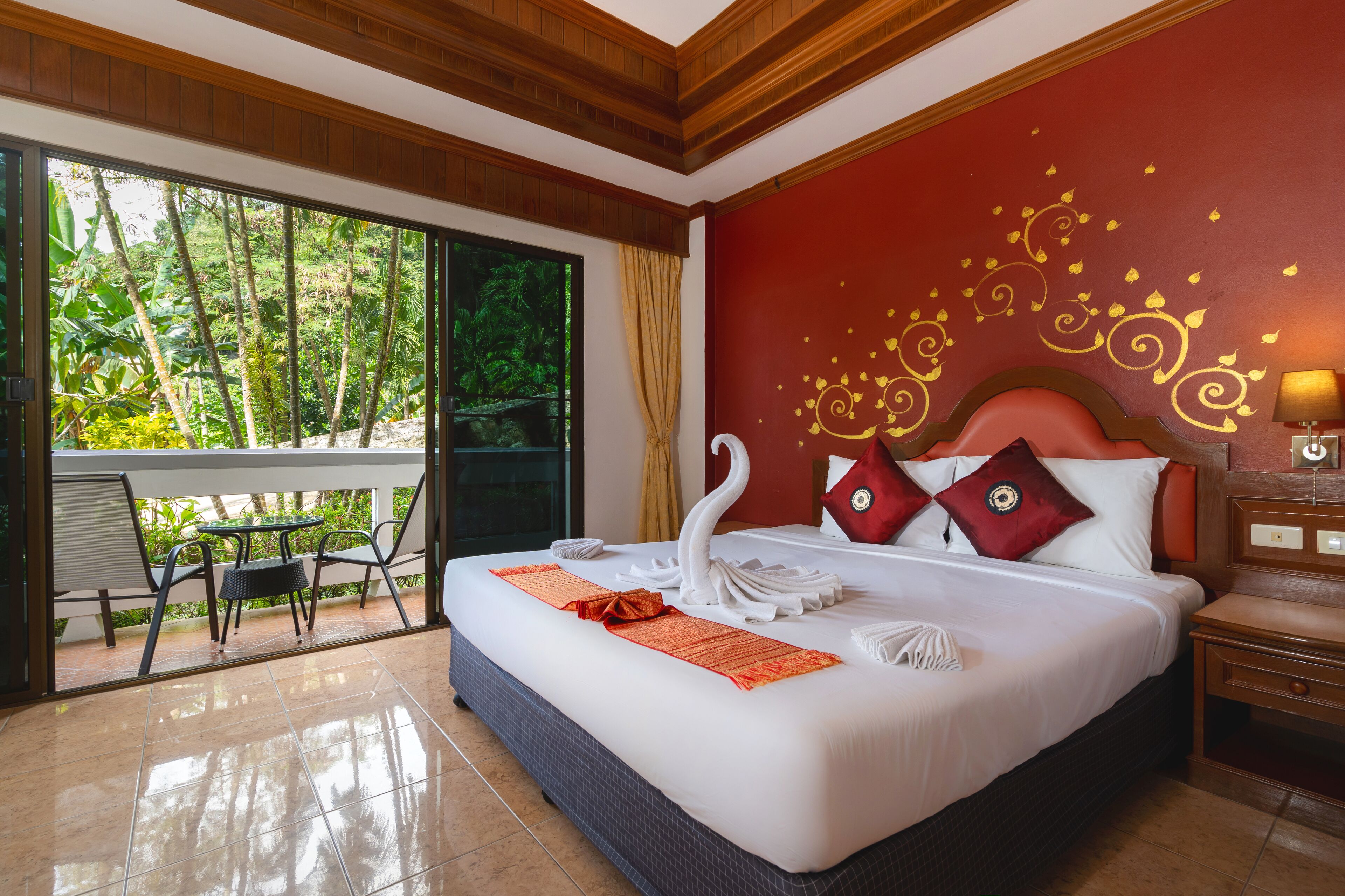 Quarto de hotel com uma cama grande, varanda com vista para vegetação e teto de madeira.