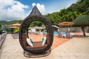 Una piscina al aire libre, sillones reclinables de piscina