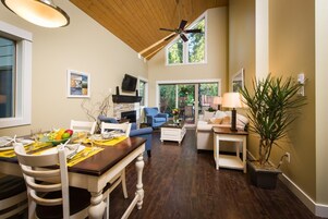 A spacious living area with a dining table, sofas, and a fireplace.