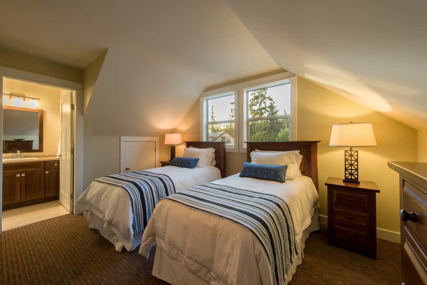 A bedroom with two beds, a window, a nightstand, and a dresser.