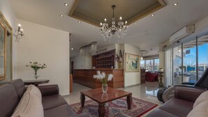 A reception area with a chandelier, a reception desk, and a view of the outside.