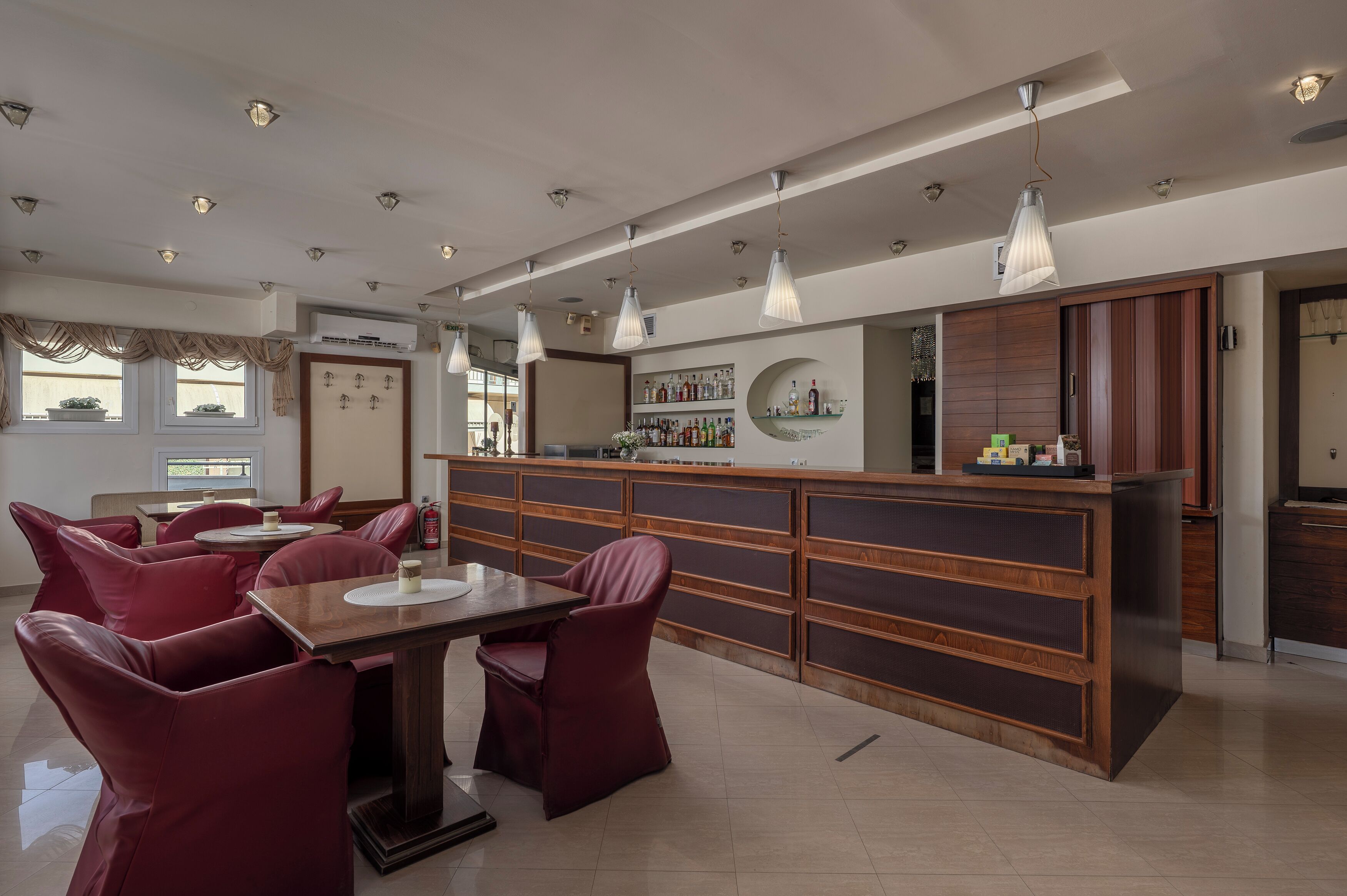 Un interior moderno con una zona de bar, asientos y cocina.
