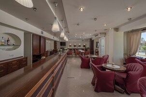Vestíbulo de hotel con mostrador de recepción, zona de estar y vistas al exterior.