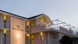 A multi-story hotel with balconies and a central column displaying the name "Hotel Villa Rosa".