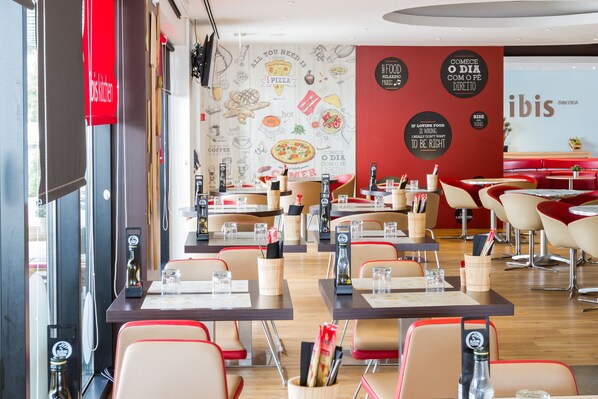 Interior de restaurante con mesas, sillas y un atril para el menú.