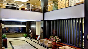 A modern lobby with a reception desk, seating area, and a decorative wall. - Aston Jayapura Hotel & Convention Center (Jayapura)