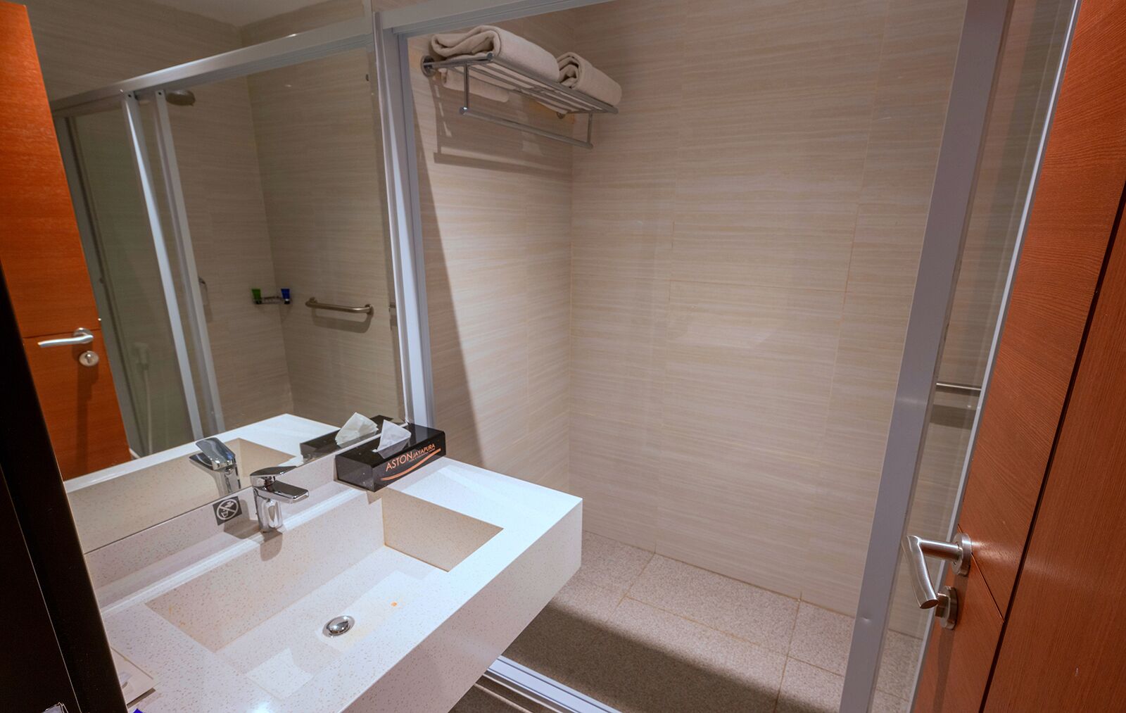 A bathroom with a white sink, a mirror, and a towel rack.