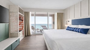 Ein Hotelzimmer mit Bett, Fernseher, Balkon mit Meerblick und einer Sitzecke.