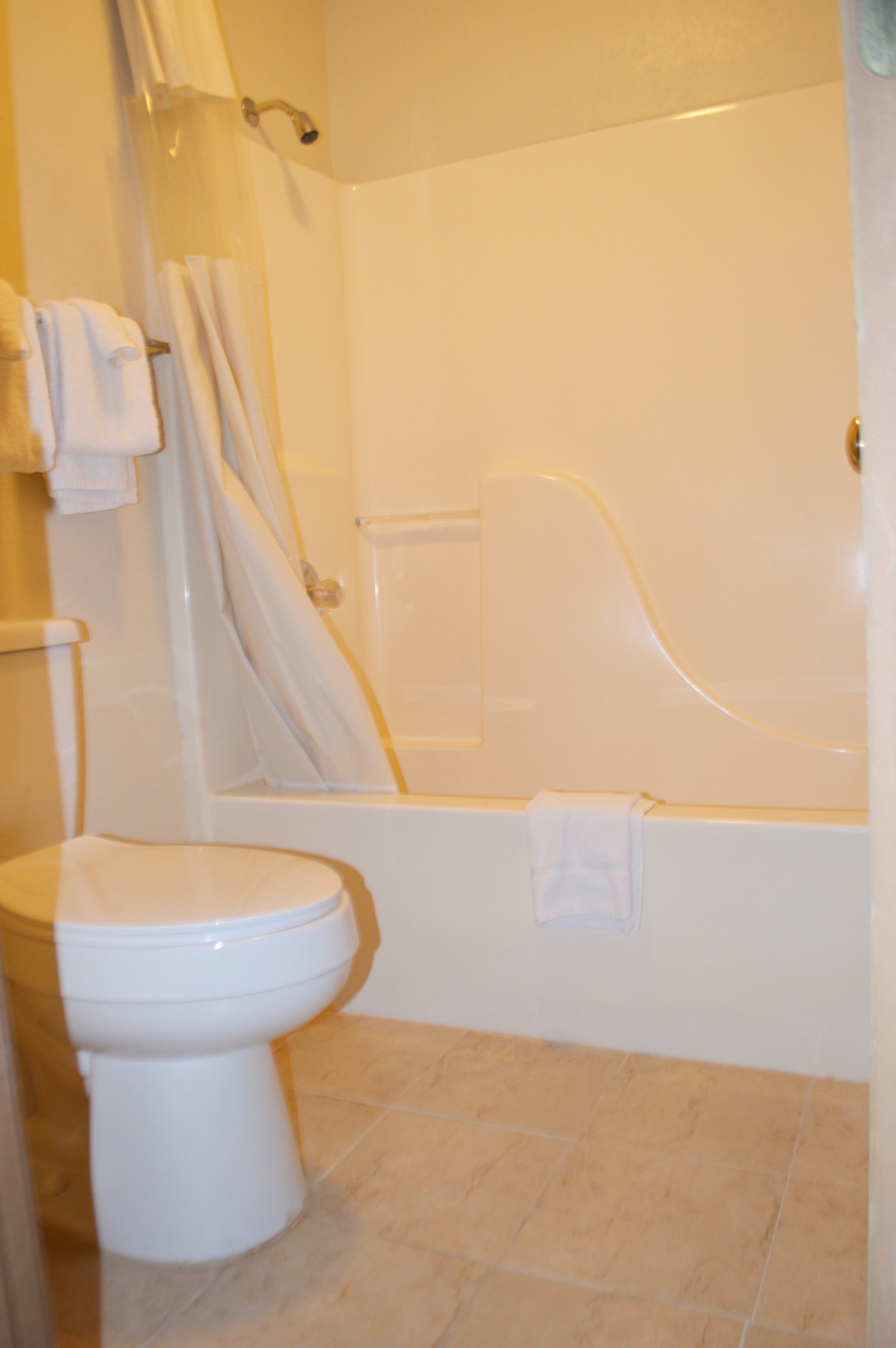 A bathroom with a toilet, a bathtub, and a shower curtain.