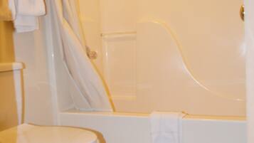 A bathroom with a toilet, a bathtub, and a shower curtain.