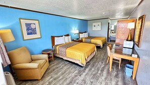 Una habitación de hotel con dos camas, un sofá, un escritorio y una silla.