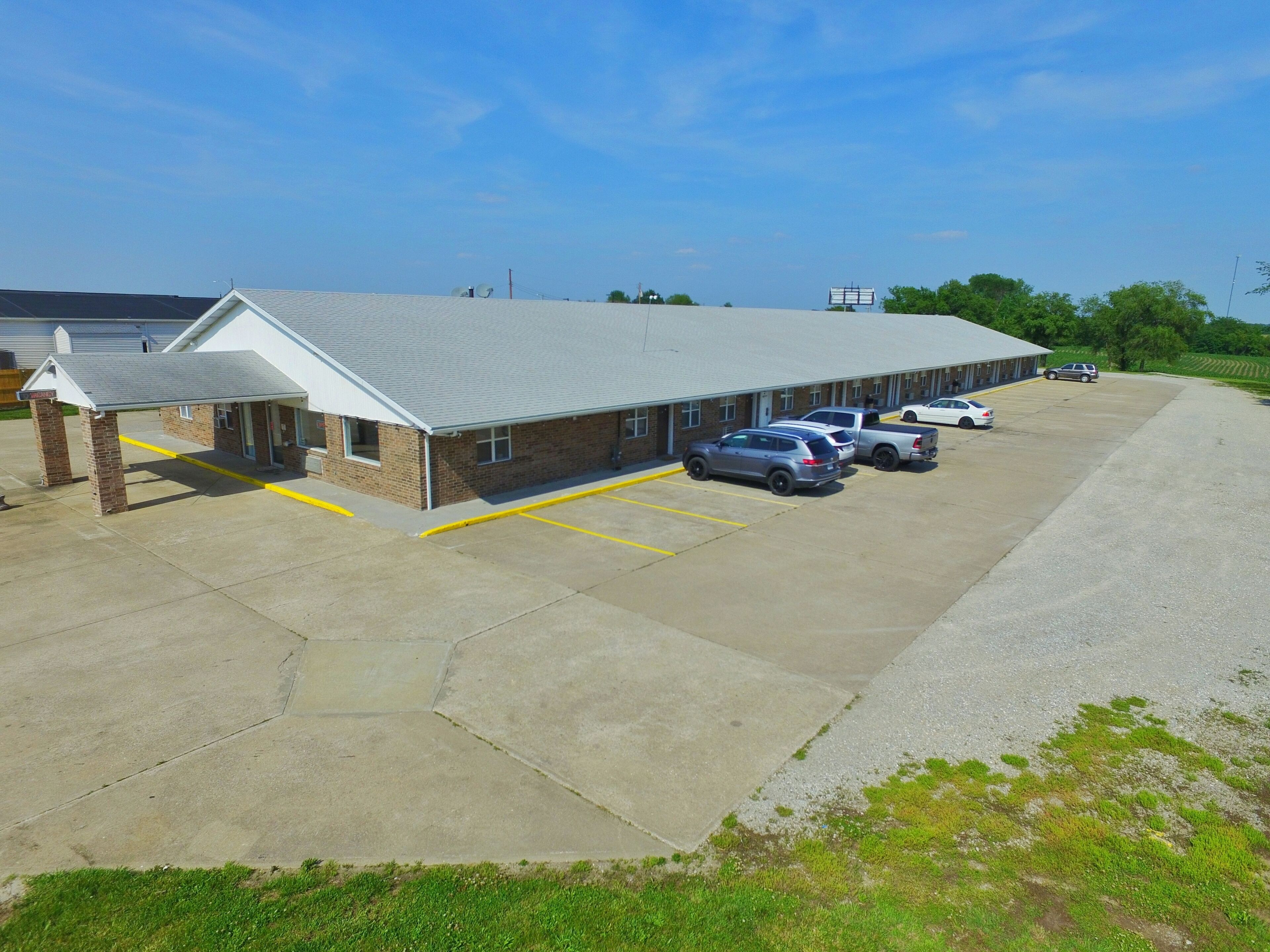 A building with a covered parking area and several cars parked.