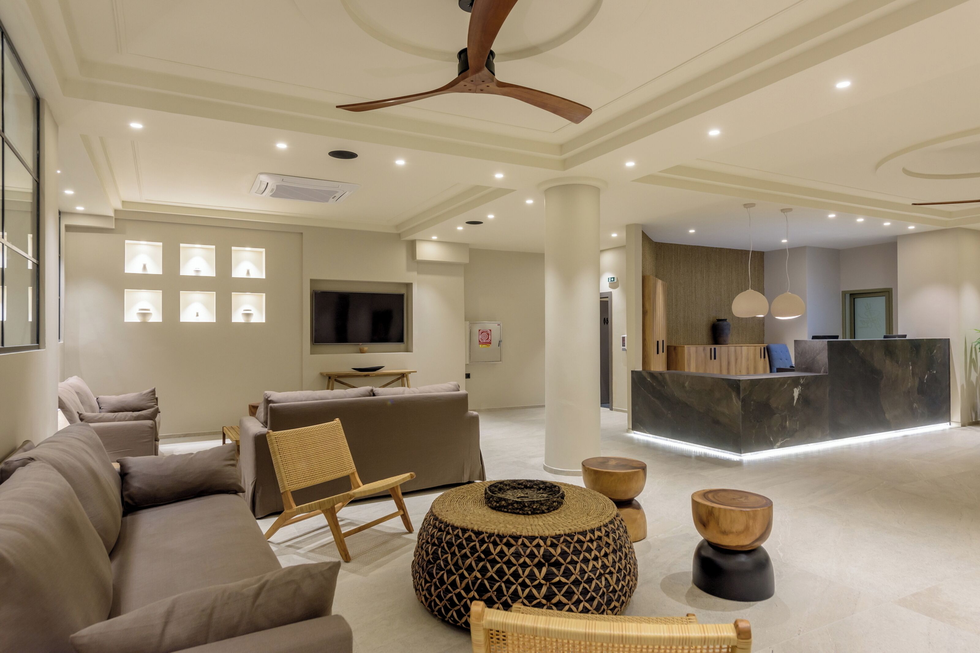 A spacious living area with a sofa, armchairs, a coffee table, and a reception desk.
