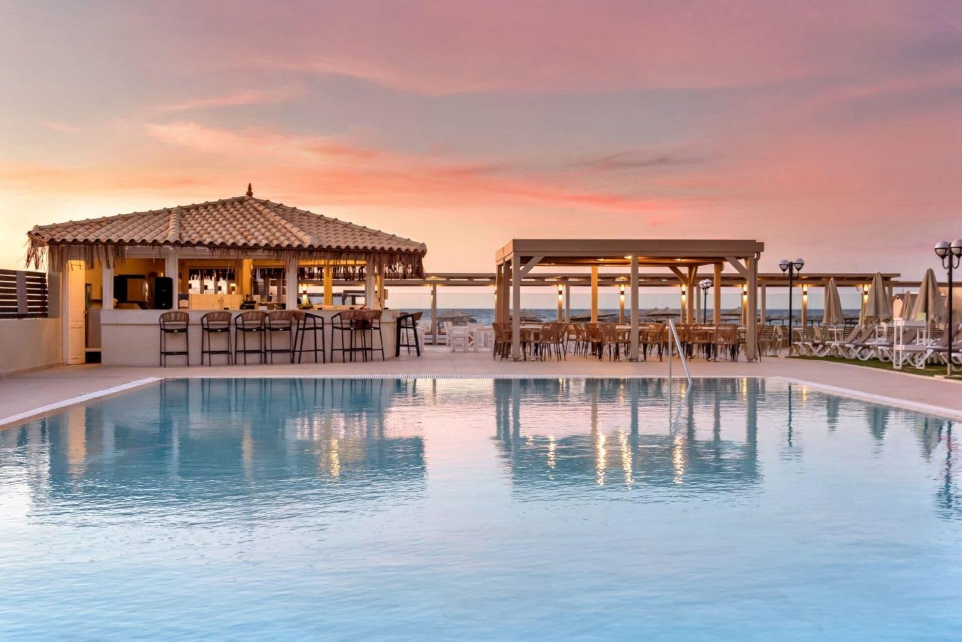 Een buitenzwembad, parasols bij het zwembad en ligstoelen