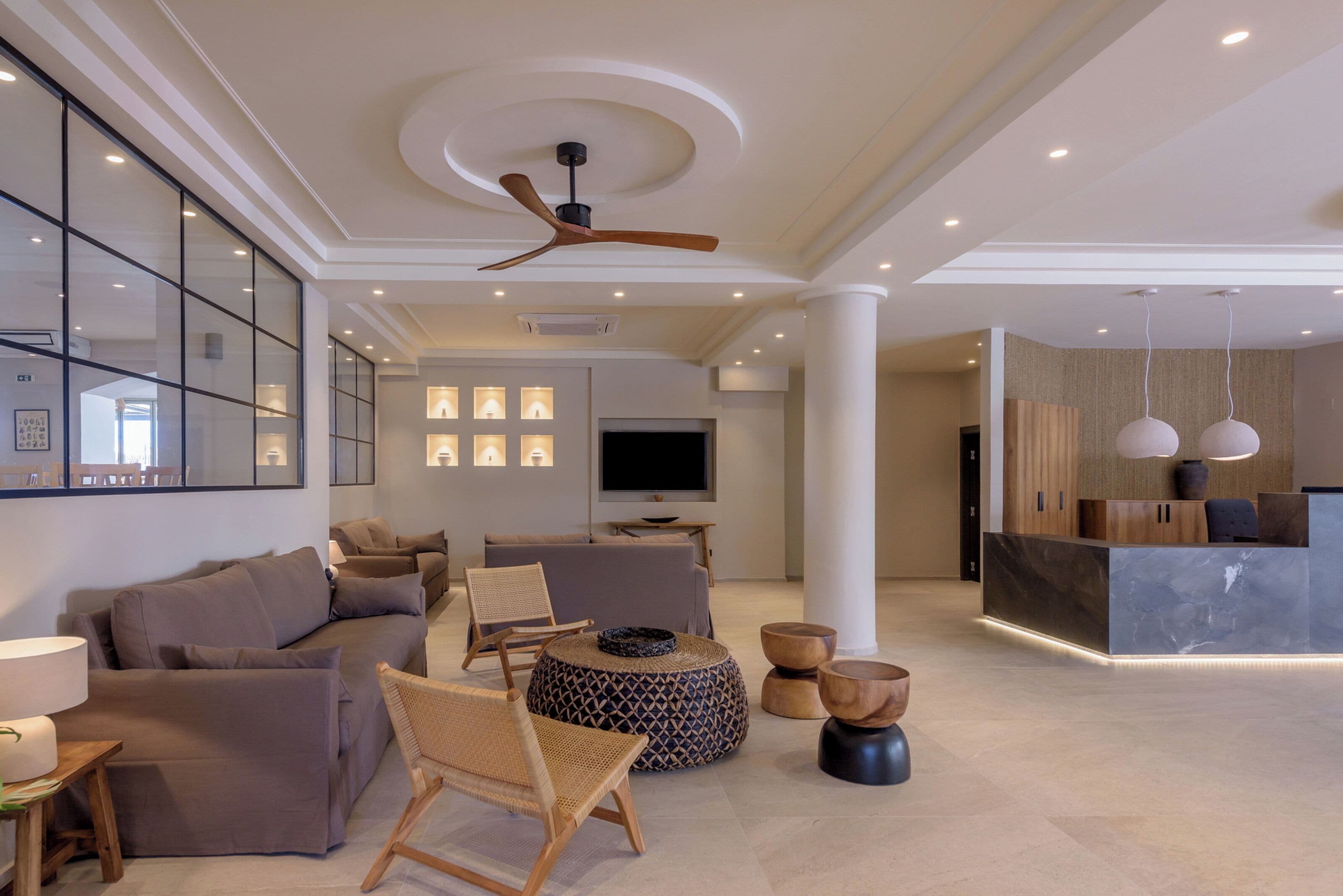 Amplia sala de estar con un conjunto de sofás, una mesa de centro y un televisor.