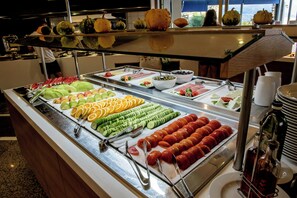 A buffet with various fruits and vegetables, including sliced cucumbers, oranges, and tomatoes. - Zeus Hotels Neptuno Beach - All Inclusive (Malevizi)