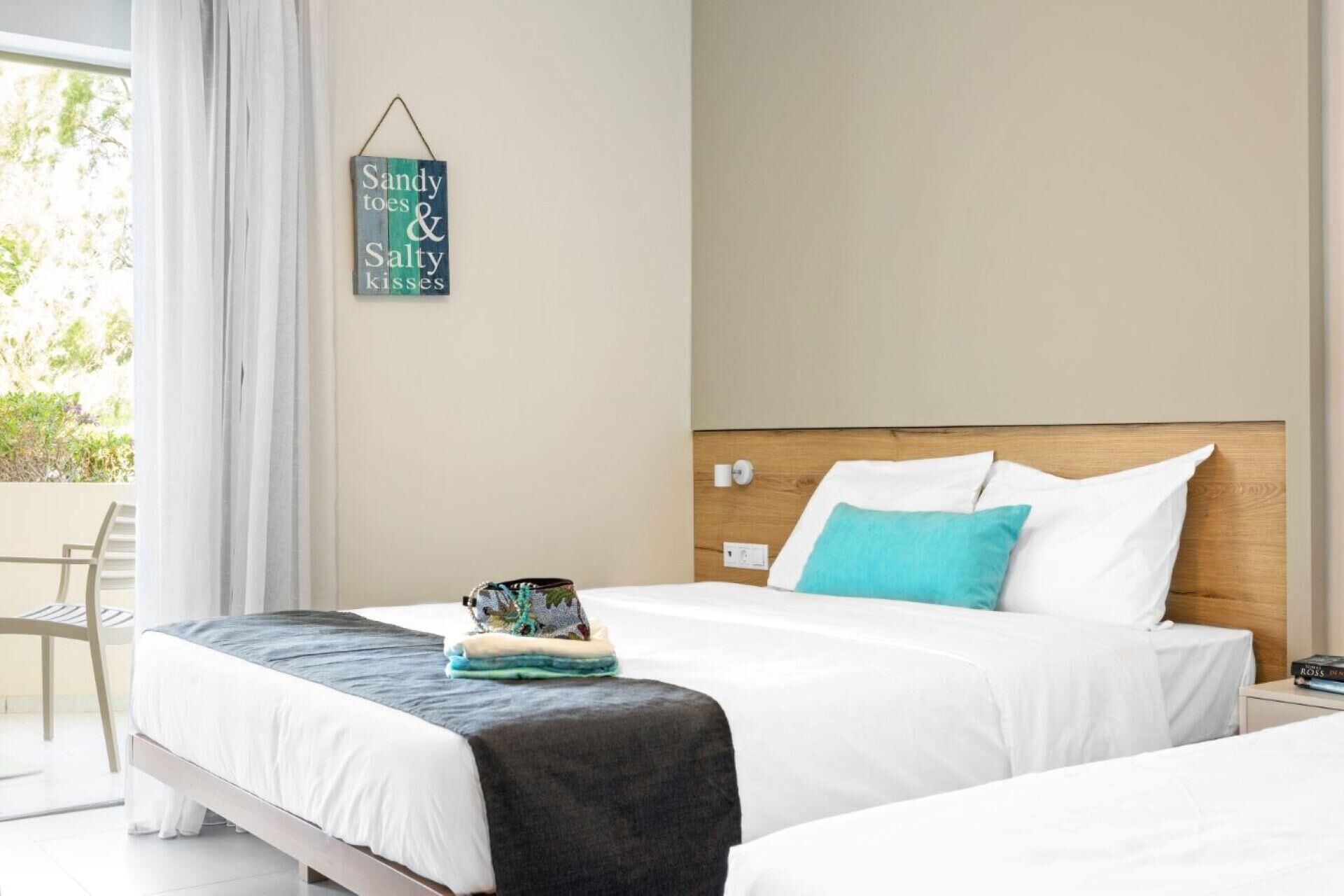 Habitación de hotel con cama, mesita de noche, una silla y un cartel en la pared.