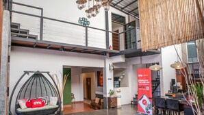 A spacious lobby with a hanging chair, a staircase, and a reception desk. - The Album Loft at Nanai (Patong)