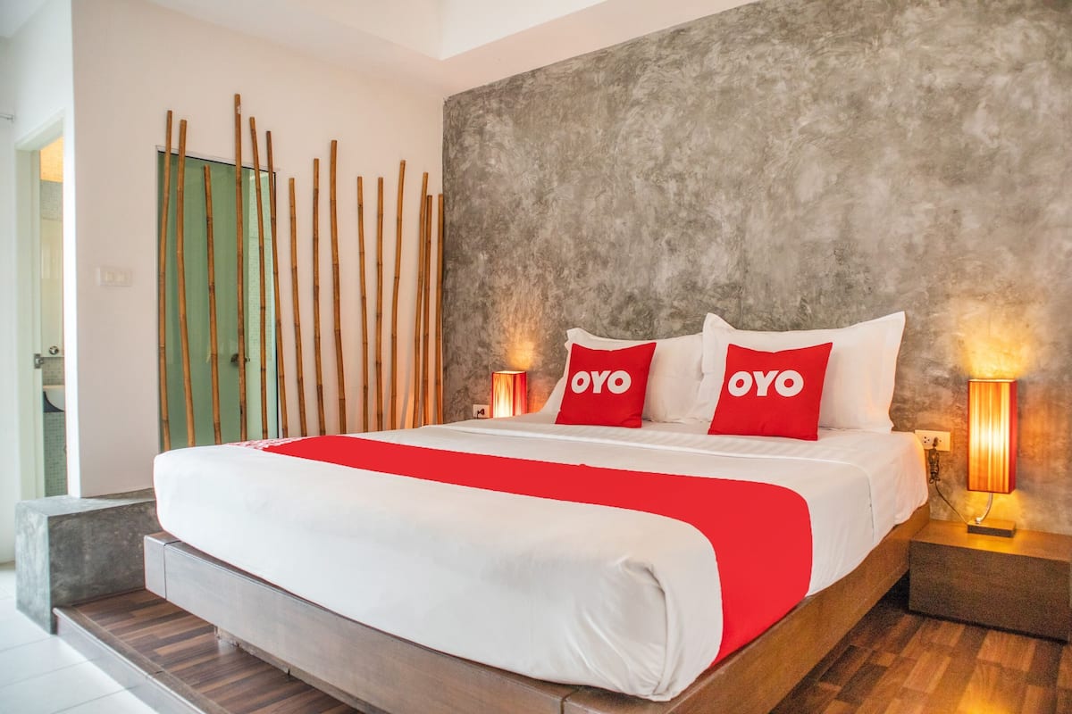 Une chambre d’hôtel moderne avec un grand lit, deux lampes de chevet et un mur à texture.
