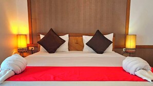 A hotel room with a wooden headboard, two bedside lamps, a red bedspread, and two towels on the bed. - The Album Loft at Nanai (Patong)