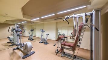 Ein Fitnessstudio mit verschiedenen Trainingsgeräten, darunter Laufbänder, Ergometer und Kraftgeräte.