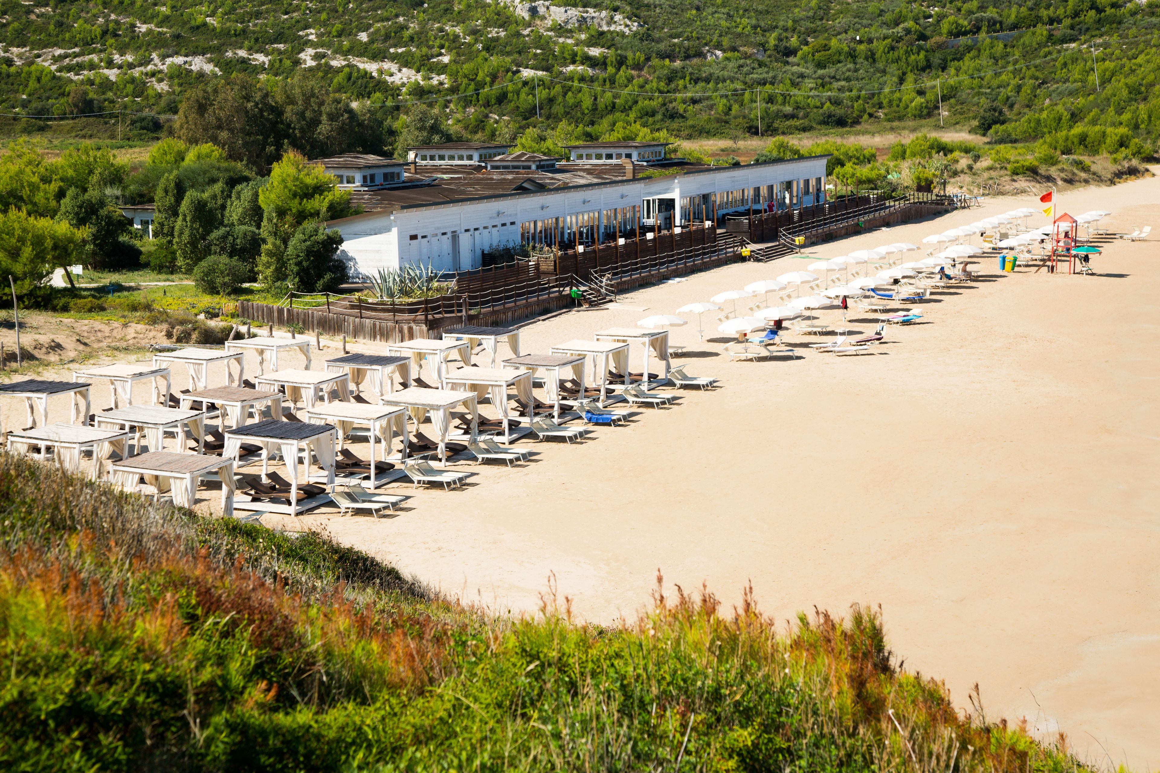 Een hotel aan het strand met verschillende kamers en een zwembad.