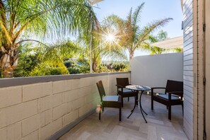 A patio with two wicker chairs and a small table, surrounded by a low brick wall and lush greenery. - Gusmay Resort – Hotel Gusmay & Suite Le Dune (Peschici)
