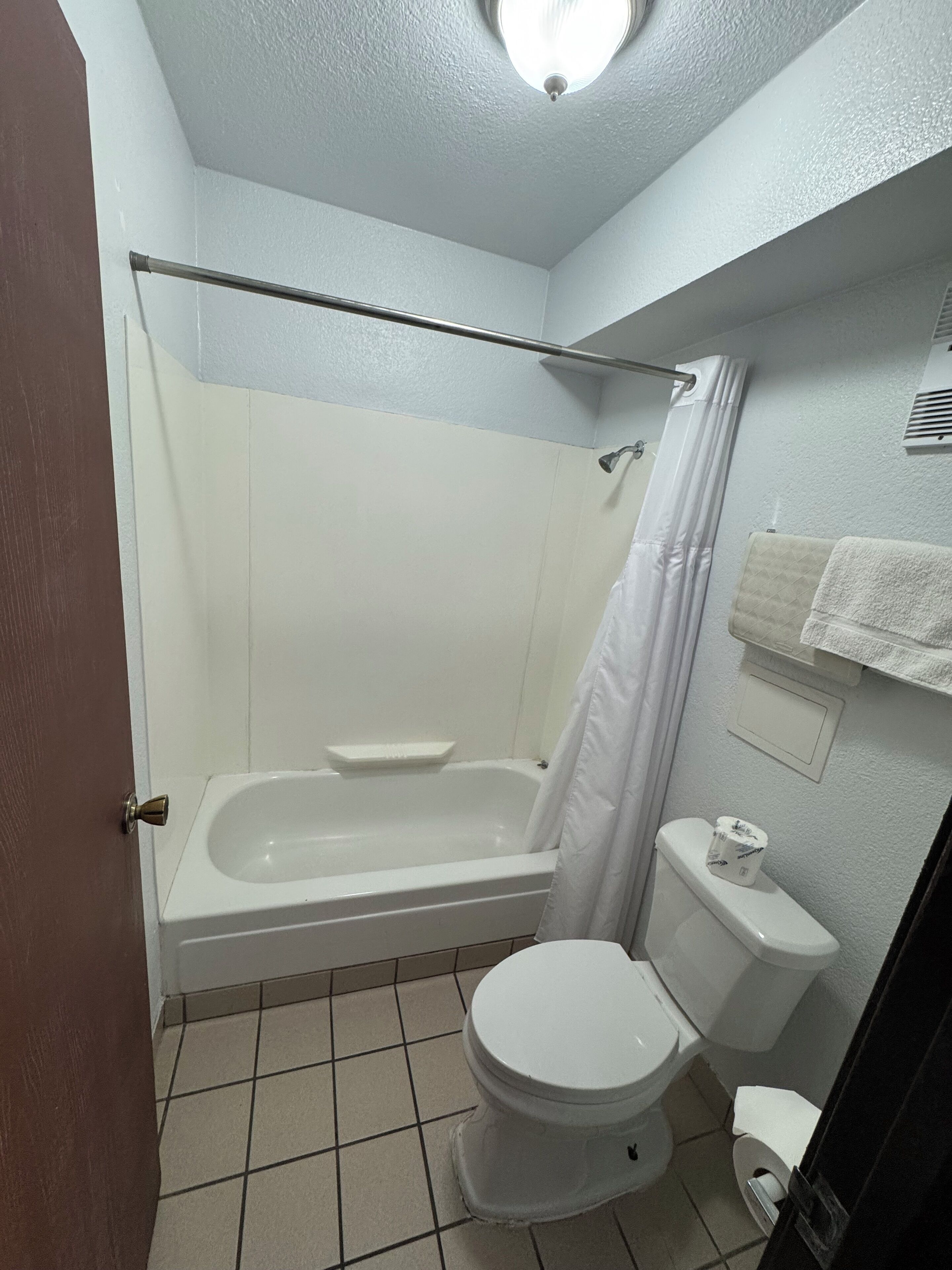 Un baño con bañera, inodoro y cortina de ducha.